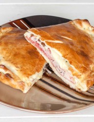 Home-made calzone loaded with various Italian cold cuts