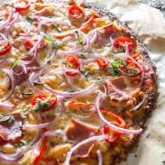 Delicious pizza with tomatoes and pancetta on a cauliflower flatbread