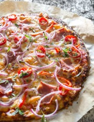 Delicious pizza with tomatoes and pancetta on a cauliflower flatbread