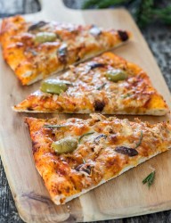 Delicious pizza combining two types of fish along with a huge stack of Corona.